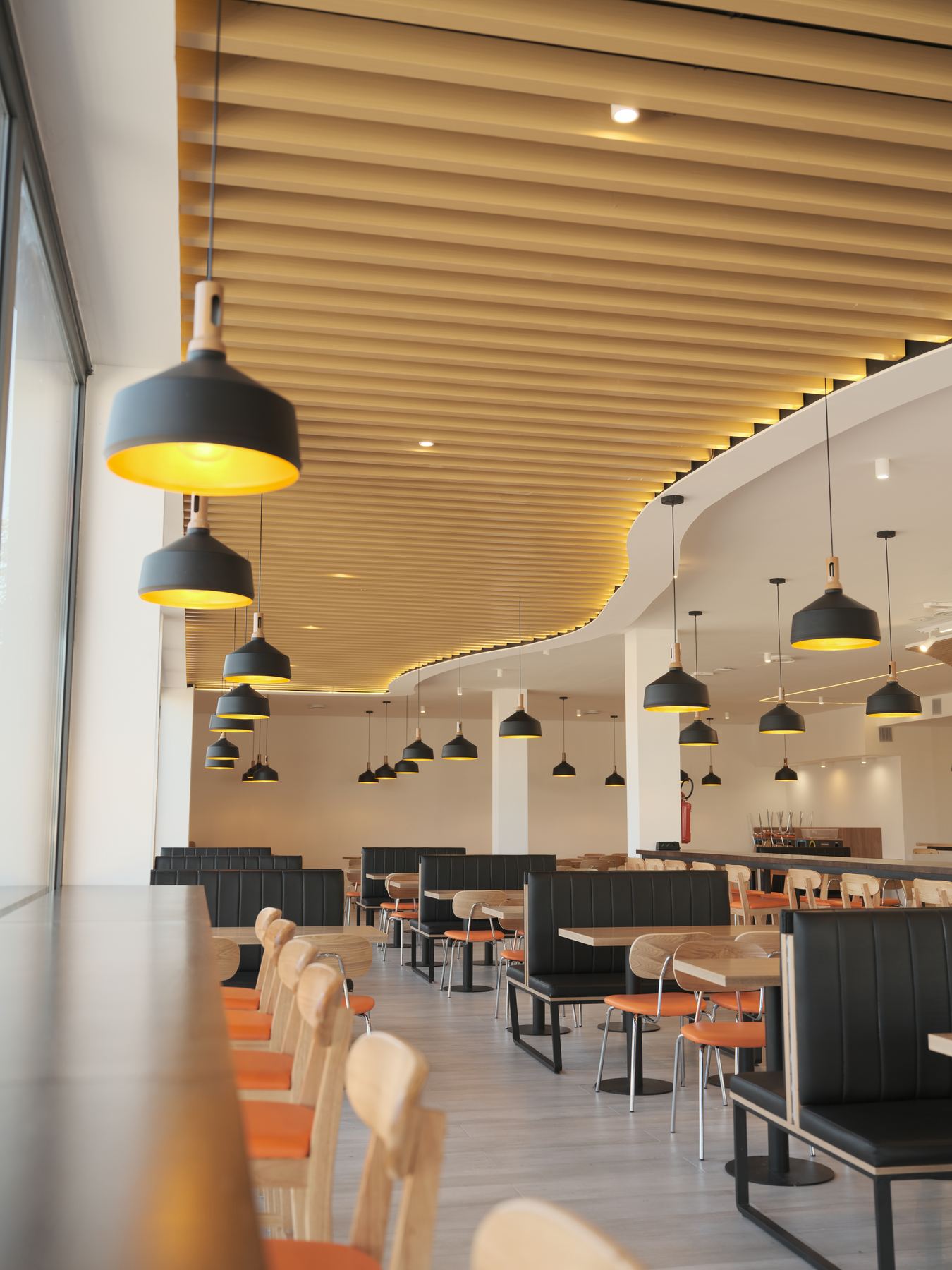 Sala LIHAY: soffitto in legno ondulato, lampade e sedute contemporanee